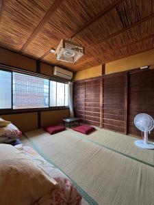 a bedroom with a bed and a ceiling with a fan at Hostel Mundo in Kyoto