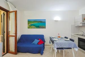 een woonkamer met een blauwe bank en een tafel bij Pineta Azzurra in Marina di Grosseto