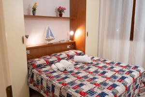 Pineta Azzurra في مارينا دي غروسيتو: غرفة فندق عليها سرير وفوط