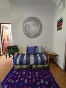 - un canapé dans le salon avec un tapis dans l'établissement Free birds hostel, à Tamraght Ouzdar