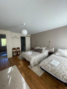 2 camas en una habitación con suelo de madera en -Les Petites Planches- Gîte Familial entre Terre & Mer, en La Haye-Pesnel