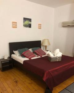 Schlafzimmer mit einem Bett mit roter Bettwäsche und Kissen in der Unterkunft Vila Rianna in Dunavăţu de Jos