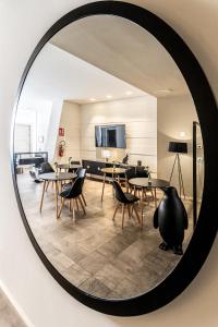 a mirror reflecting a room with tables and chairs at Neko Boutique Hotel in Cagliari
