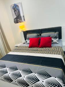 1 dormitorio con 2 almohadas rojas en Appart City, en Fort-de-France