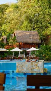 un par de personas sentadas en una piscina en Bio Rio Hotel en San Jerónimo