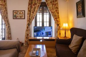 a living room with a couch and a tv at La Casa de la Lela in Setenil