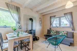 - un salon avec une table, des chaises et un canapé dans l'établissement Biale Domki Kopalino, à Kopalino