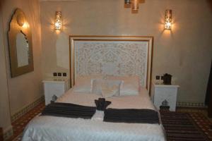 梅克內斯的住宿－Riad Golf Stinia，一间卧室配有一张带2个床头柜的大型白色床
