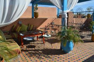 a patio with chairs and a couch and a table at Riad Golf Stinia in Meknès