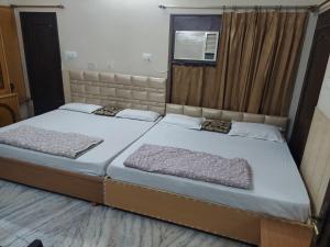 1 dormitorio con 2 camas y ventana en Rk Lodge, en Amritsar