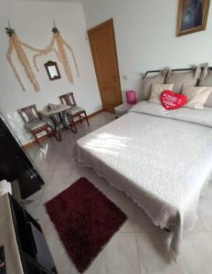 ein Schlafzimmer mit einem großen weißen Bett mit roten Kissen in der Unterkunft La casa di Mihaela in Cinquale