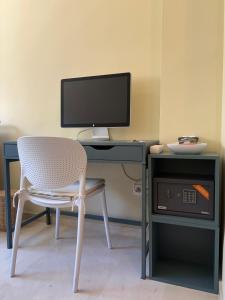 a computer desk with a chair and a computer monitor at Work and Rest Away From Home in Paterna