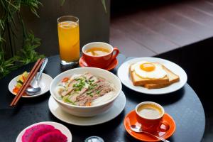 a table with plates of food and a bowl of eggs and toast at Wilque Hotel Hanoi in Hanoi +96 photos