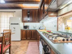 uma cozinha com armários de madeira e um forno com placa de fogão em CASA VACANZE PERLA em Partinico