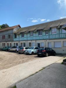 uma fila de carros estacionados em frente a um edifício em Au réconfort de Mers Draps et Serviettes fournies Appartement 12 em Mers-les-Bains