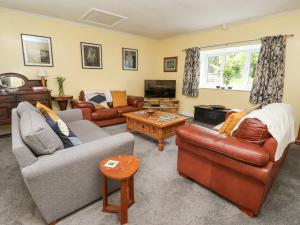 a living room with two couches and a tv at Millers Cottage in Malton