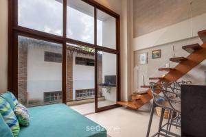 a living room with a large window and a staircase at CPR - Apartamentos a 200m da praia com Piscina in Marau