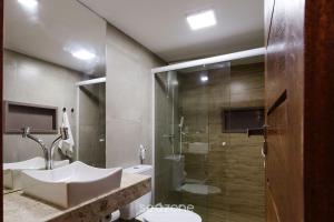 a bathroom with a sink and a shower at CPR - Apartamentos a 200m da praia com Piscina in Marau