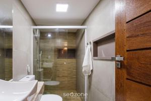 a bathroom with a shower and a toilet and a sink at CPR - Apartamentos a 200m da praia com Piscina in Marau
