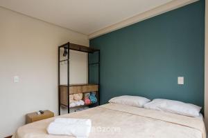 a bedroom with a bed and a green wall at CPR - Apartamentos a 200m da praia com Piscina in Marau
