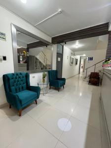 una sala de espera con 2 sillas azules y un espejo en Miskisol, en Piura