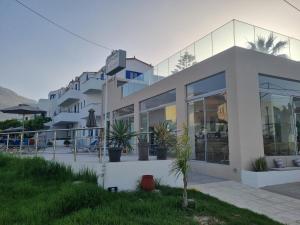 un edificio blanco con plantas delante en Leonidas Studios & Apartments, en Georgioupolis