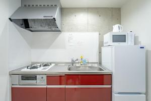 a kitchen with a sink and a microwave at Hotel Paradiso Miyakojima in Miyako Island