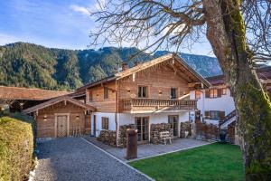バイリッシュツェルにあるexklusives Alpenchalet mit Jacuzzi & Sauna für bis zu 14 Personenのポーチと庭付きの大きな木造家屋