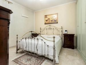 um quarto com uma cama e um quadro na parede em CASA VACANZE PERLA em Partinico