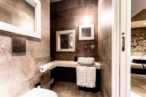 a bathroom with a sink and a toilet at Neko Boutique Hotel in Cagliari