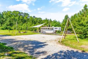 an rv parked on a gravel road with two swings at Wild Horse Retreat in Conway