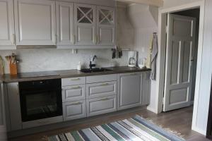 a kitchen with white cabinets and a sink at Vareid Panorama Lofoten Vareidstua in Vareid