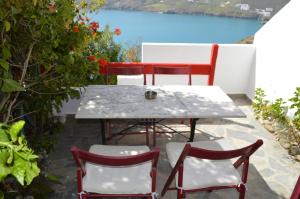 a table and chairs on a patio with a view of the water at The Red-Fish House in Astypalaia +67 photos