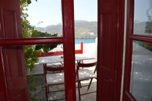 a view of a table and chairs from a window at The Red-Fish House in Astypalaia