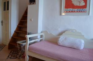 a white bench with a pink cushion and a stair case at The Red-Fish House in Astypalaia Town