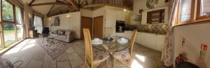 una cucina con tavolo in vetro in una camera di The Round House at Boningale Manor a Wolverhampton