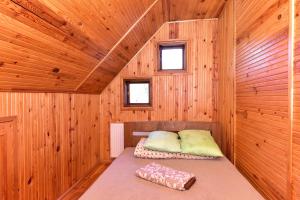 een kamer met een bed in een houten hut bij Sodyba Paštys Poilsinė in Vozgėliai