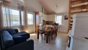 een woonkamer met een bank en een tafel en een keuken bij Villa Magnolia 2 Himos in Jämsä