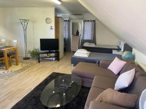 uma sala de estar com um sofá e uma mesa em Gäst lägenheten med egen terrass em Falkenberg