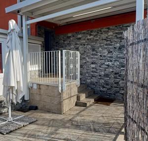 eine Terrasse mit einem Zaun und einer Steinmauer in der Unterkunft LE MURA Foresteria in Grassobbio