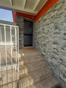 - un mur en pierre et des escaliers avec une porte dans l'établissement LE MURA Foresteria, à Grassobbio