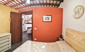 Un dormitorio con una pared de color naranja y una cama. en Appartamenti Fior Di Loto, en Trapani