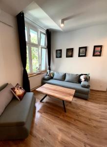 a living room with two couches and a coffee table at Apartament przy Rynku Świętego Antoniego in Wrocław