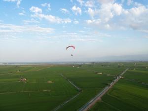 a kite flying in the sky over a green field at Apartamento VALLFOGONA Relax in Santa Bárbara