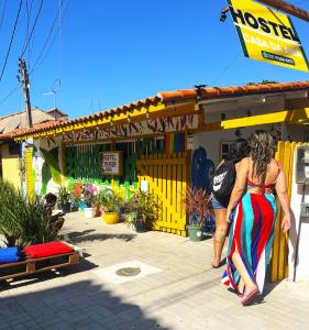 Una mujer con un vestido colorido parada frente a una tienda en Hostel casa da ana, en Búzios
