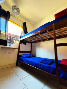 布希奥斯Hostel casa da ana的一间卧室配有两张双层床,铺有蓝色床单。
