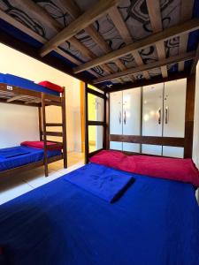 布希奥斯Hostel casa da ana的一间卧室配有两张双层床,铺有蓝色床单。