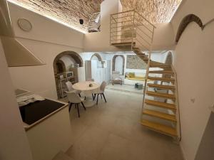a kitchen with a spiral staircase and a living room at Filangieri 28 in Bernalda