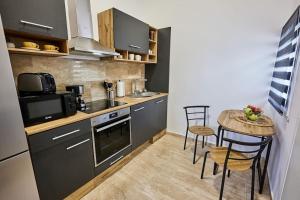 a small kitchen with a table and chairs in a room at Várfal Apartman in Sopron