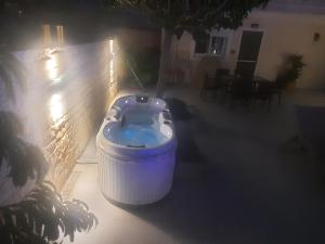 een groot blauw bad dat 's nachts op een patio zit bij Amare suite in Perivólia